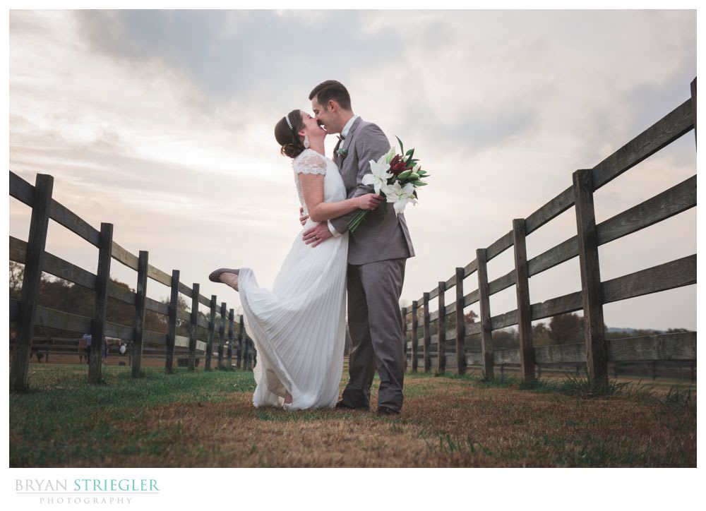 bride and groom with wood fences
