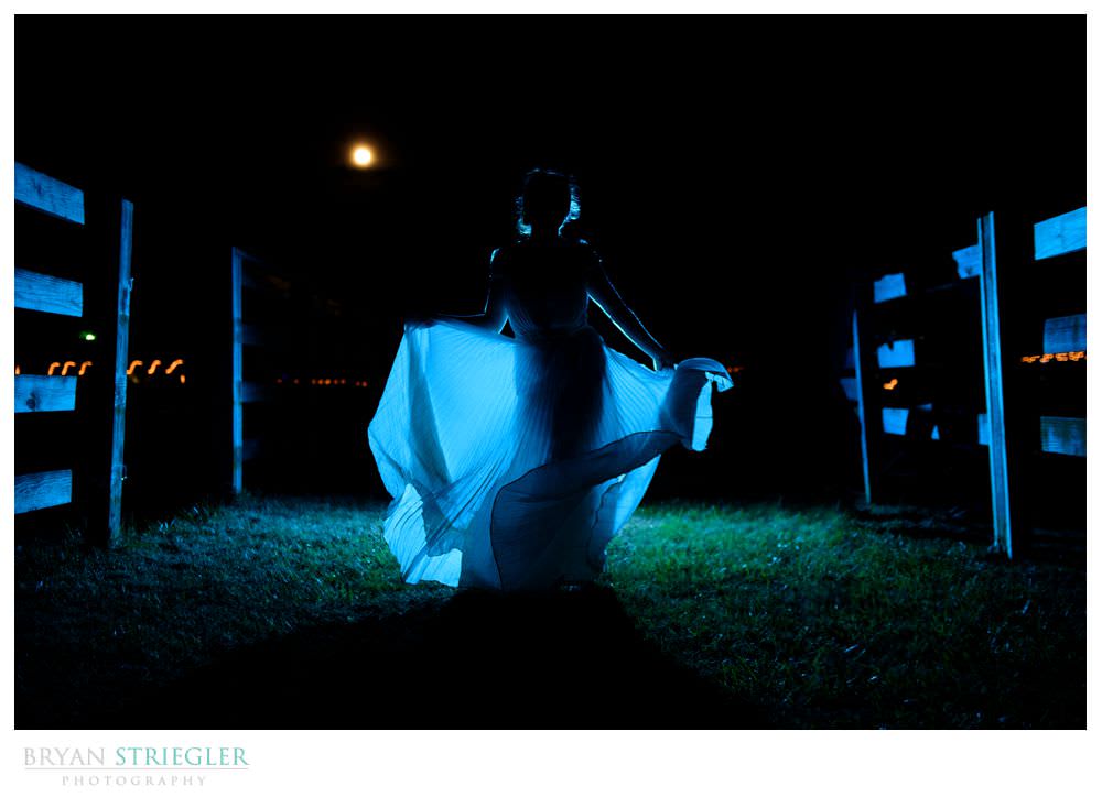 Dramatic photo of bride dancing at night with a full moon
