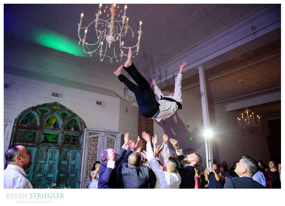 groom being tossed into the air