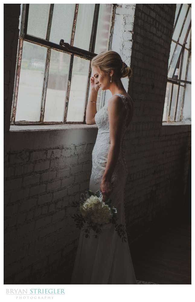 bride posing in front of large window