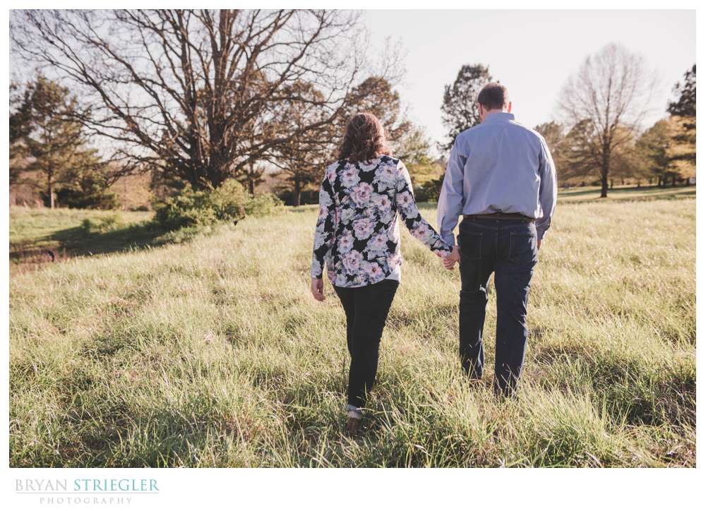 walking through a field during engagement session