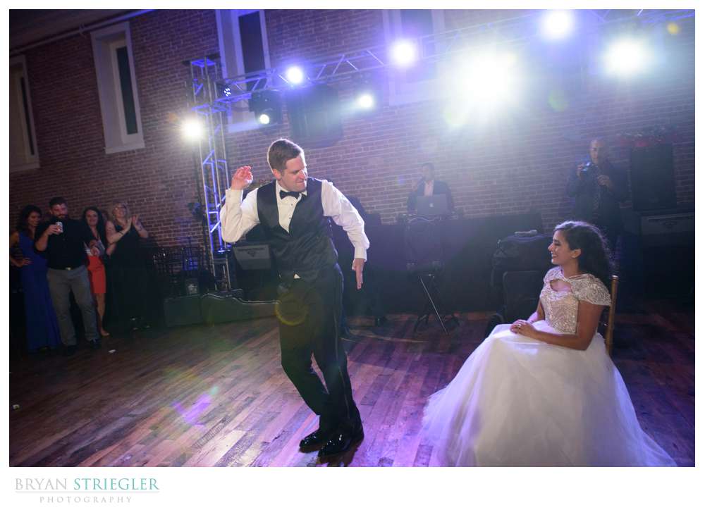 groom dancing for bride before garter