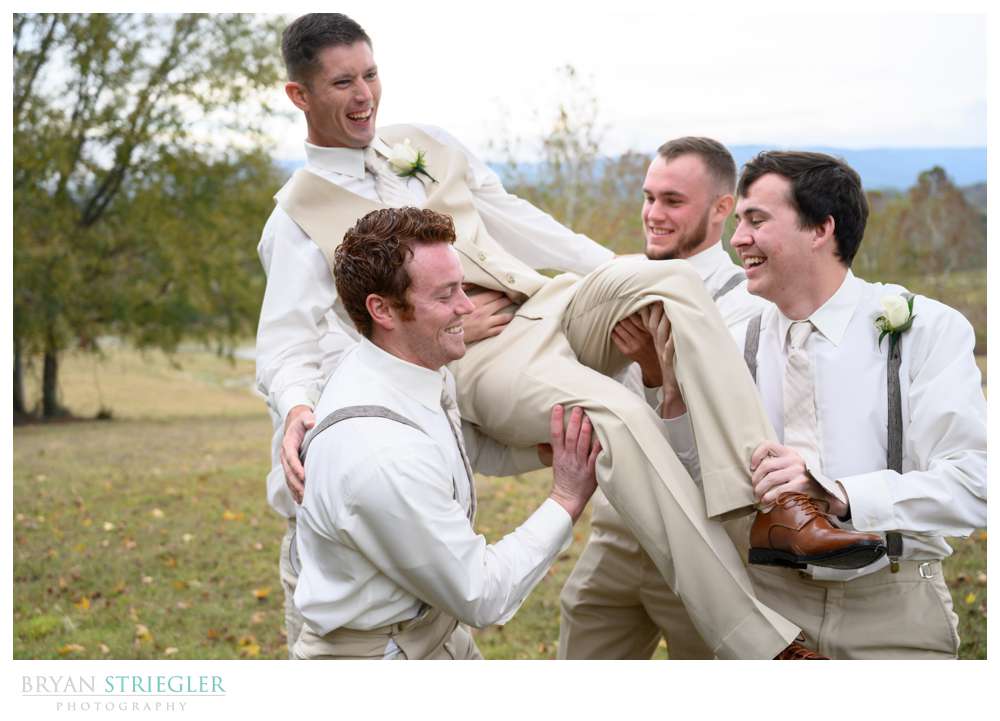 groomsmen picking up groom