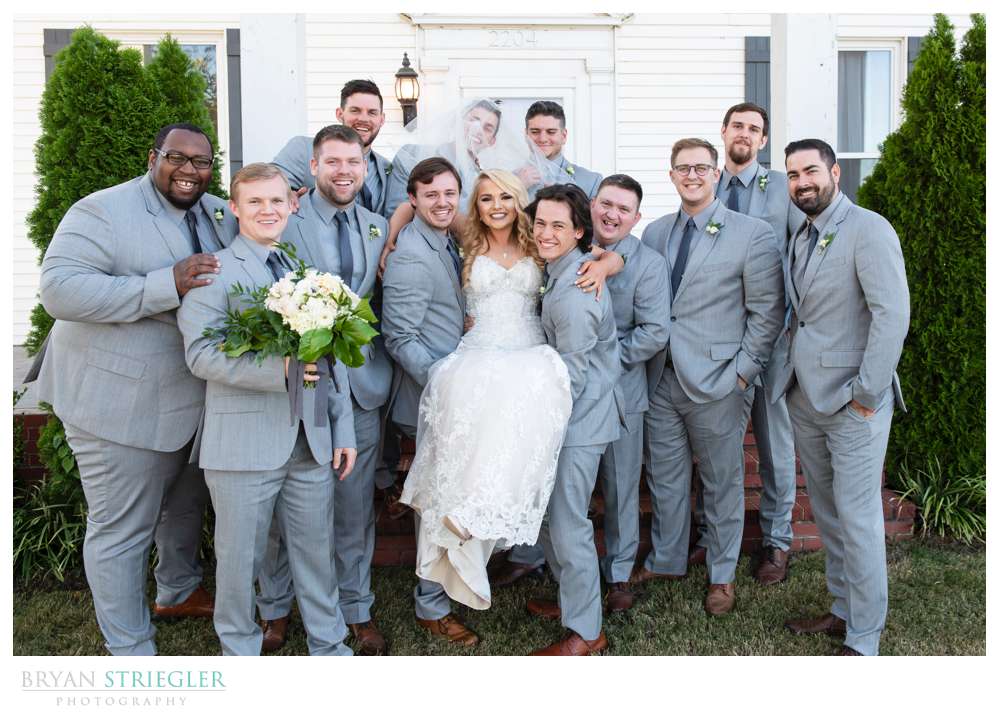 guys lifting up bride