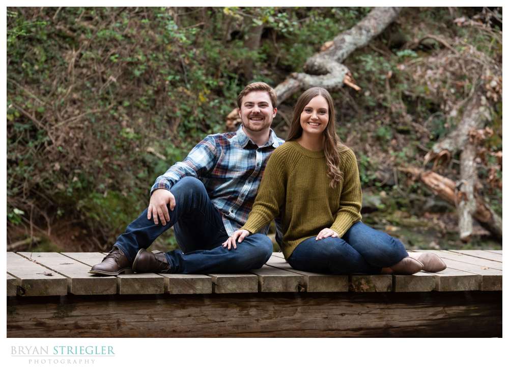 couple sitting on bridge