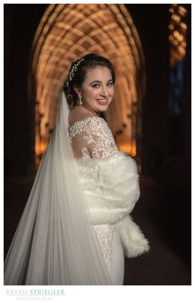 bride at night in front of glass chapel