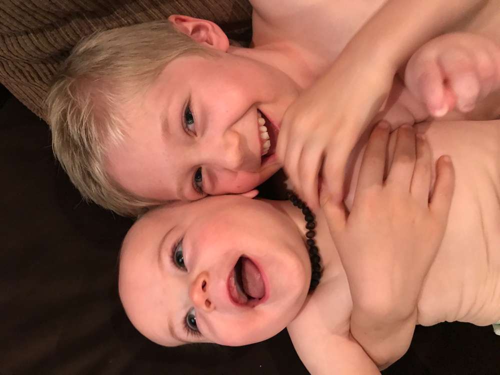 big brother holding little brother and laughing