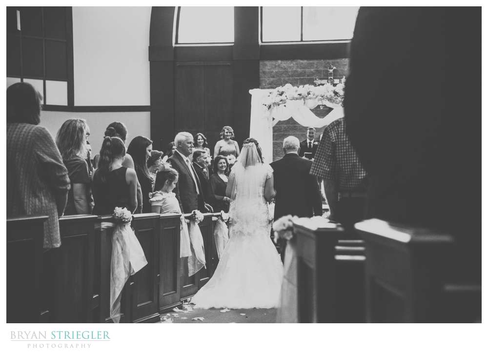 back view of father walking bride