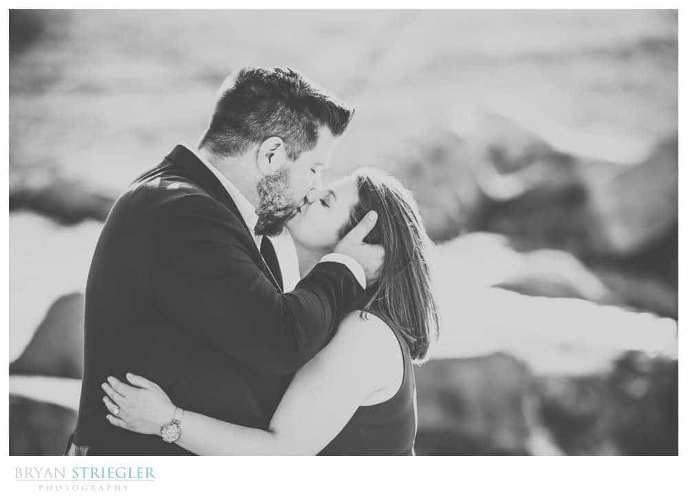 kissing by creek engagement photo