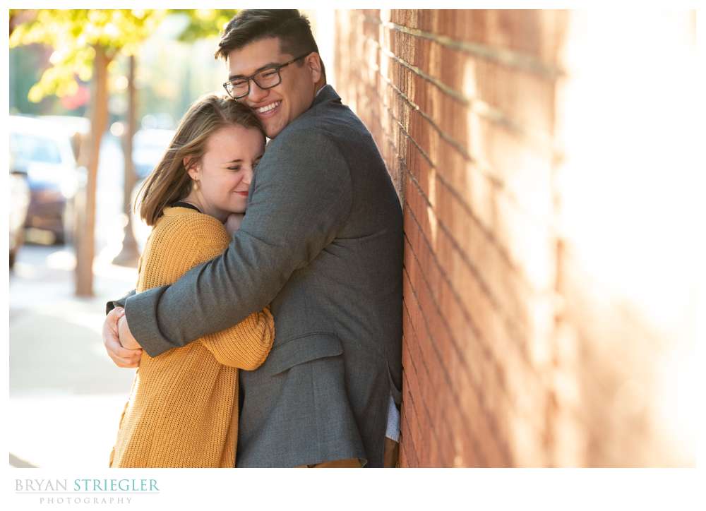 leaning against brick wall engagement photo