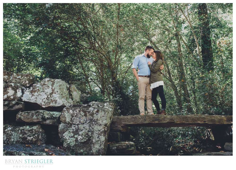 couple standing on rock bridge
