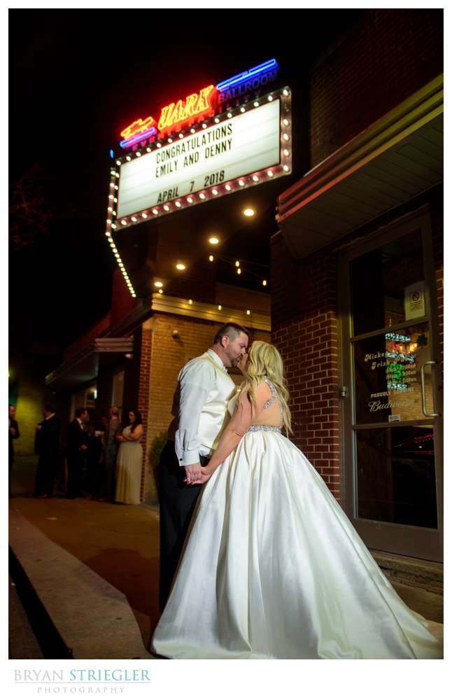 couple kissing in front of Uark bowl