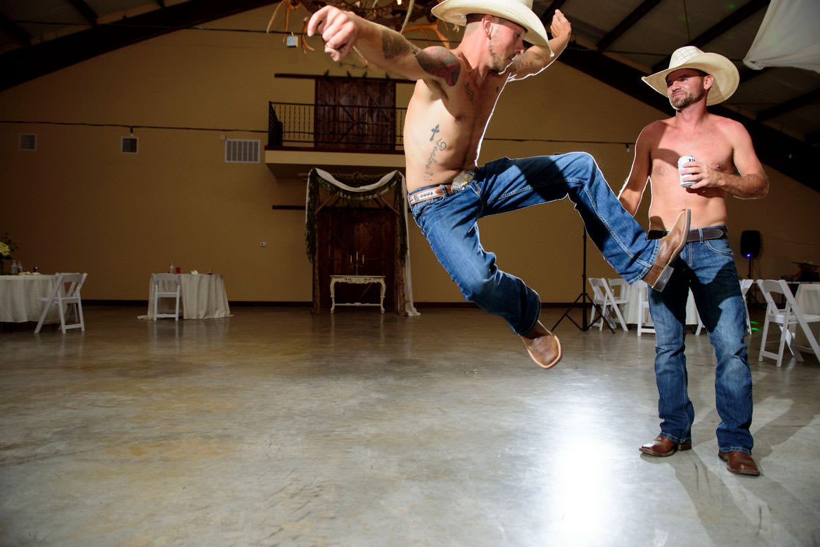 cowboys jumping and dancing at wedding