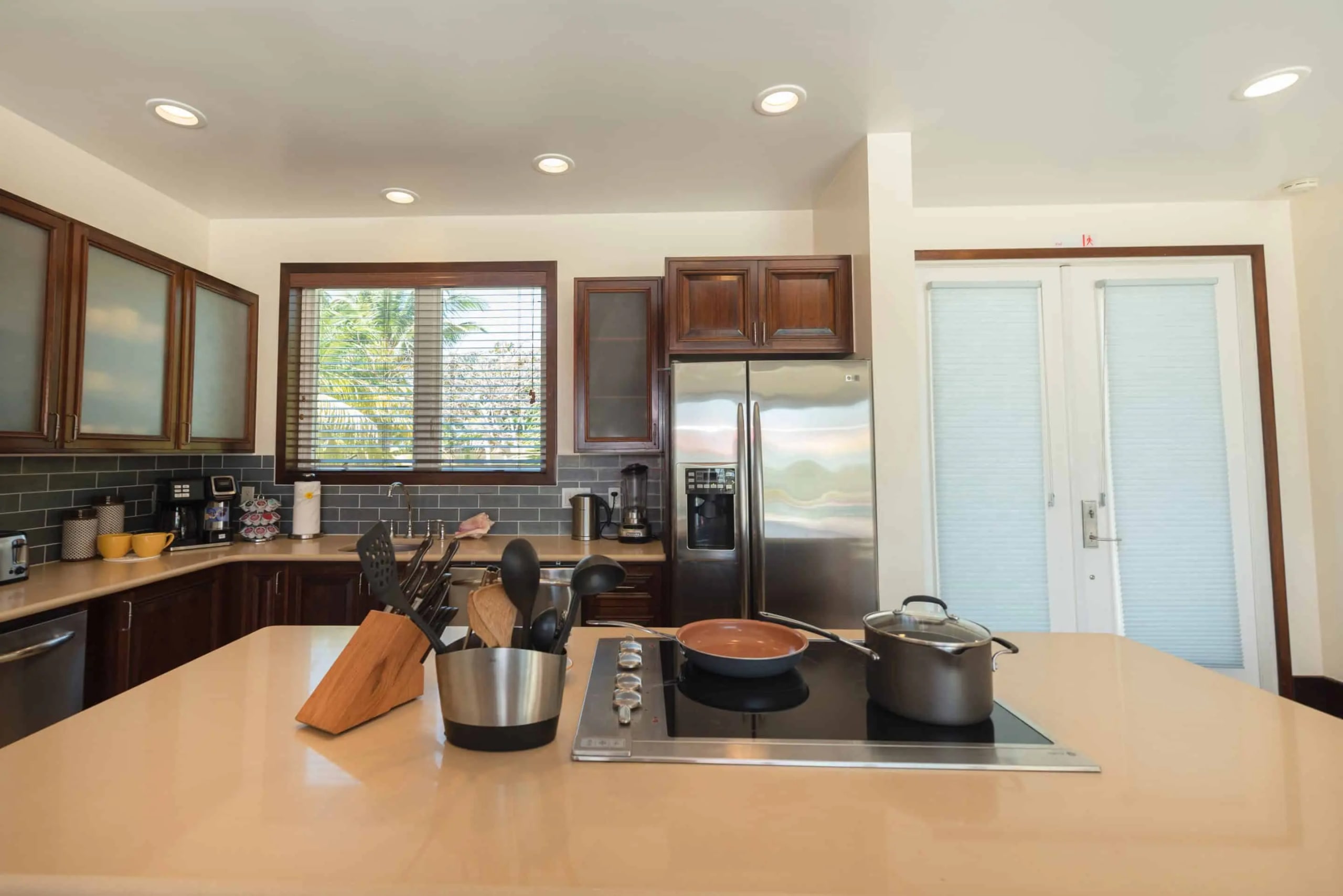 Villa kitchen with a wide cooking island, hardwood cabinetry, and garden windows