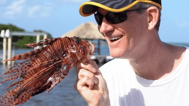 Guest holding up a lionfish catch