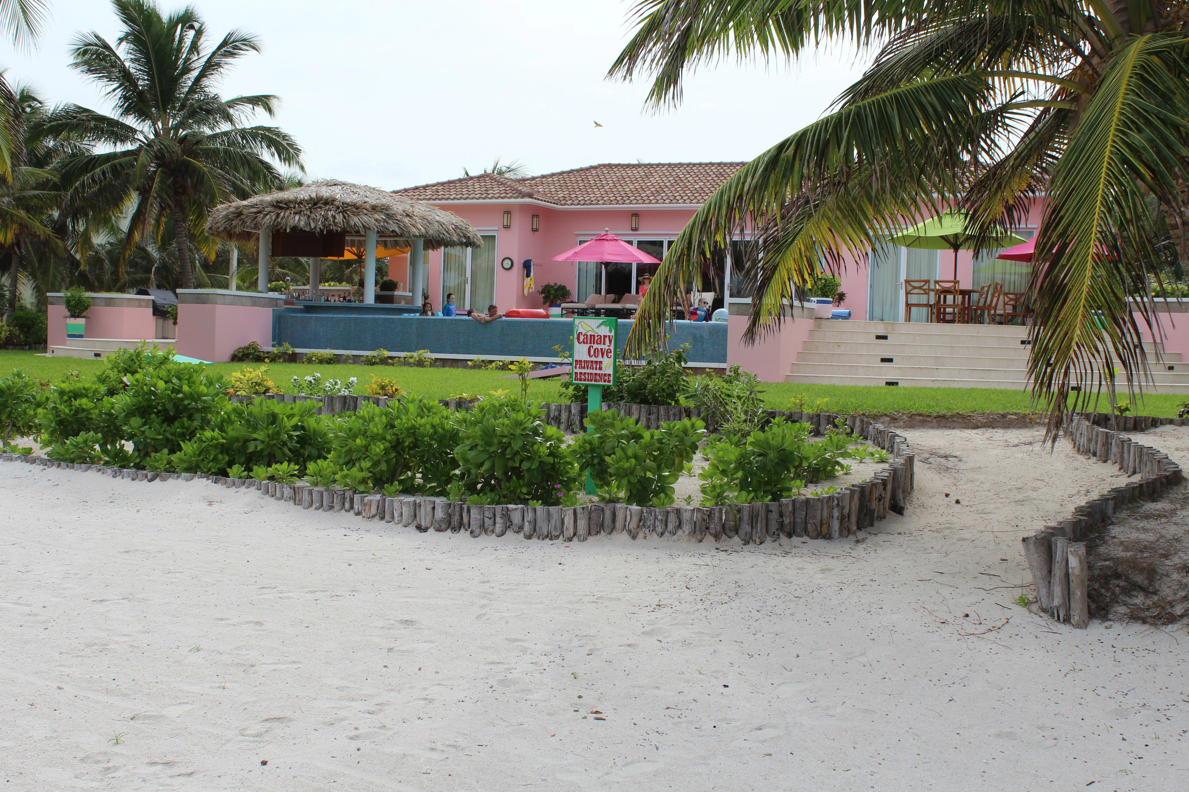 Beach path view of the pink Canary Cove villa and pool terrace