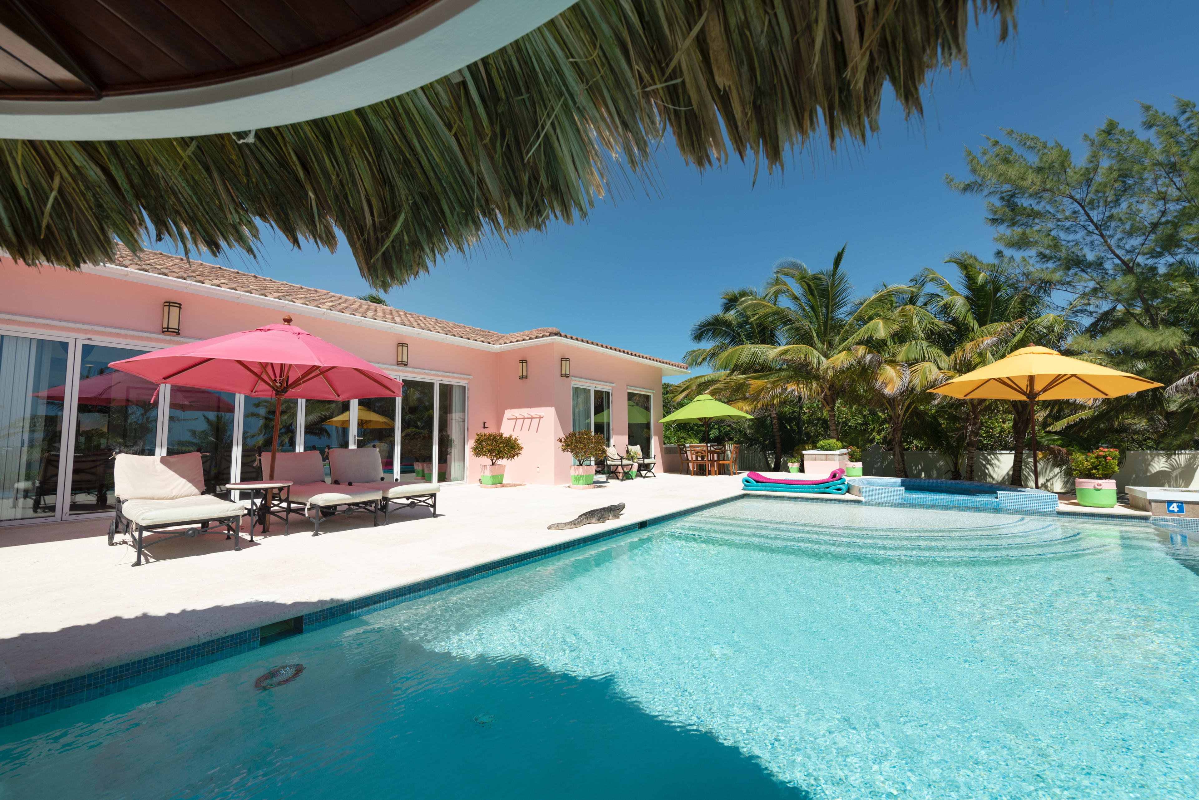 Pool deck with shaded loungers beside the villa