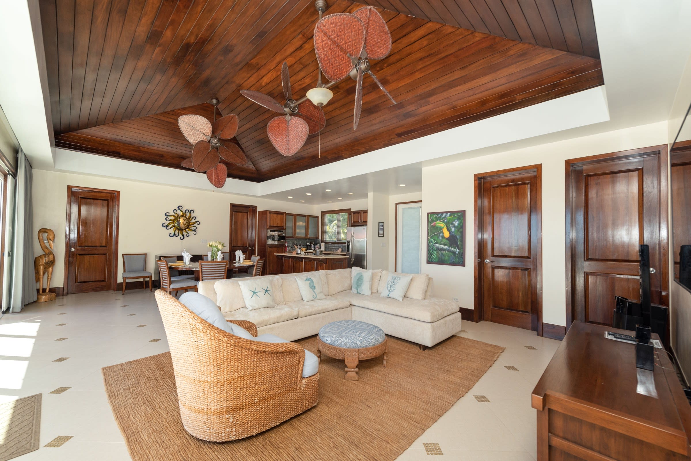 Expansive great room with sculptural ceiling fans, relaxed furnishings, and seamless indoor-outdoor flow.