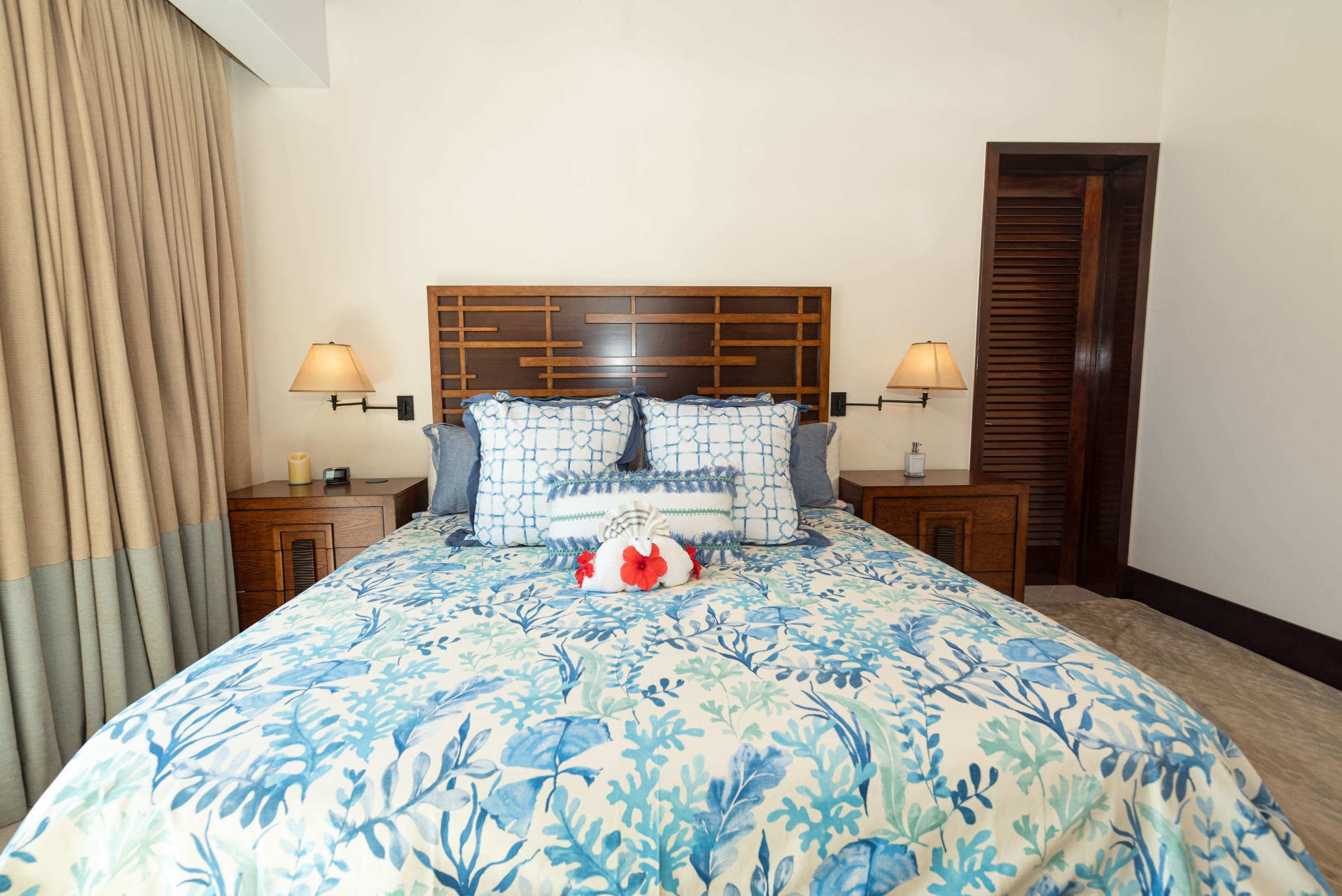 Tranquil guest suite bedroom with direct patio access and serene botanical linens.