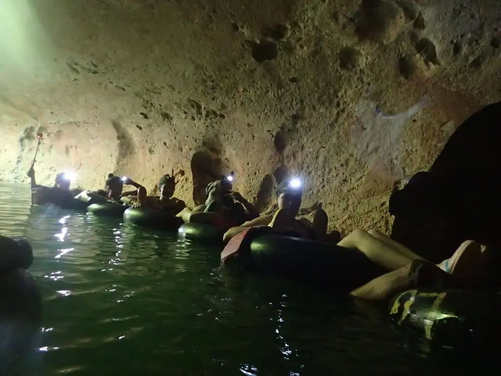 Guests floating through a cave on an inner tube