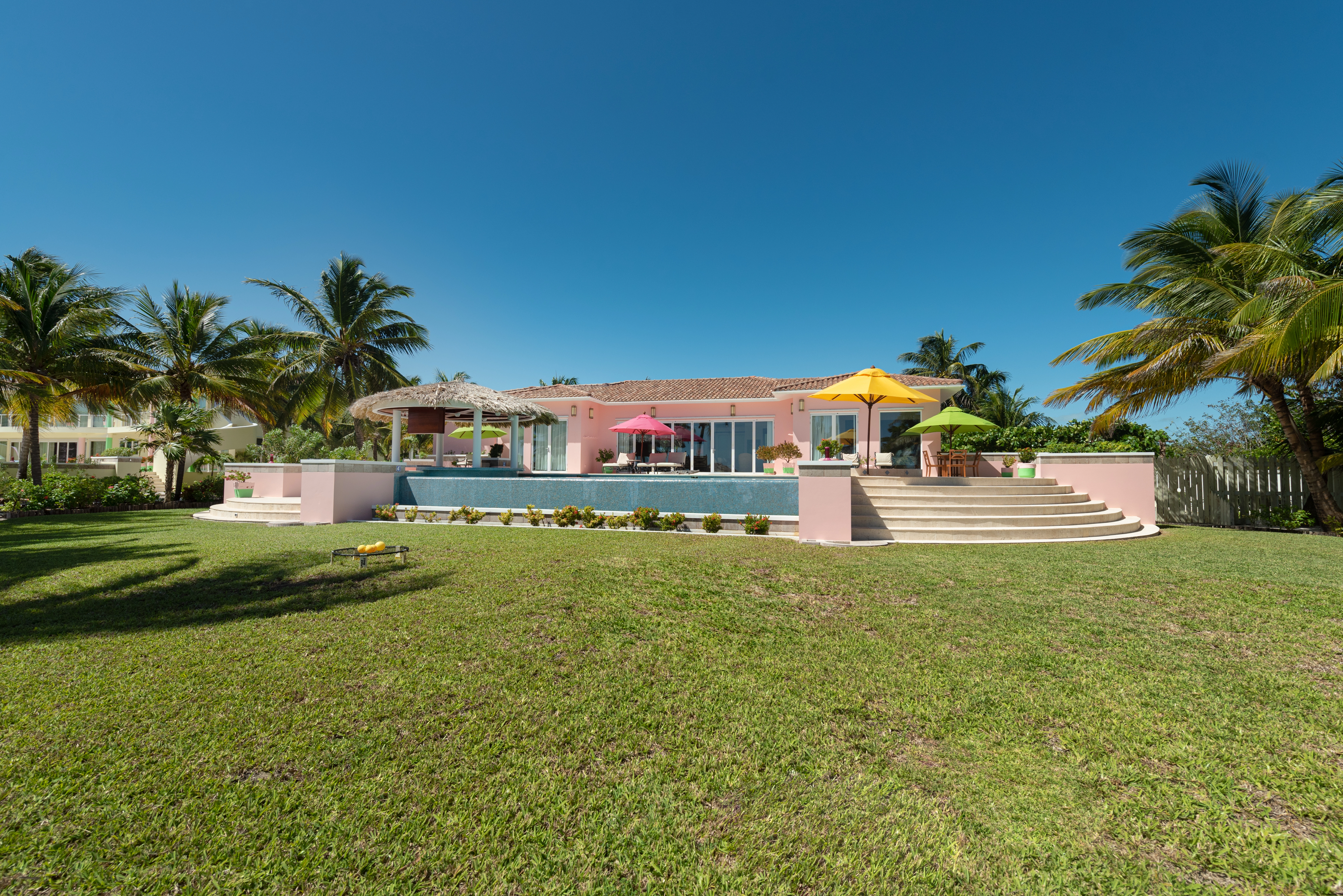 Lawn view of the villa, pool, and terrace