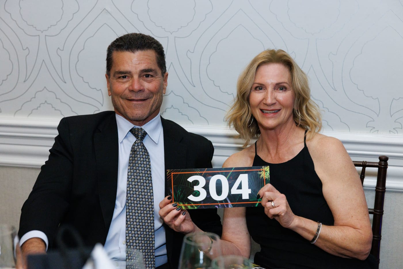 Guests holding their paddle number at the 2024 Annual Auction