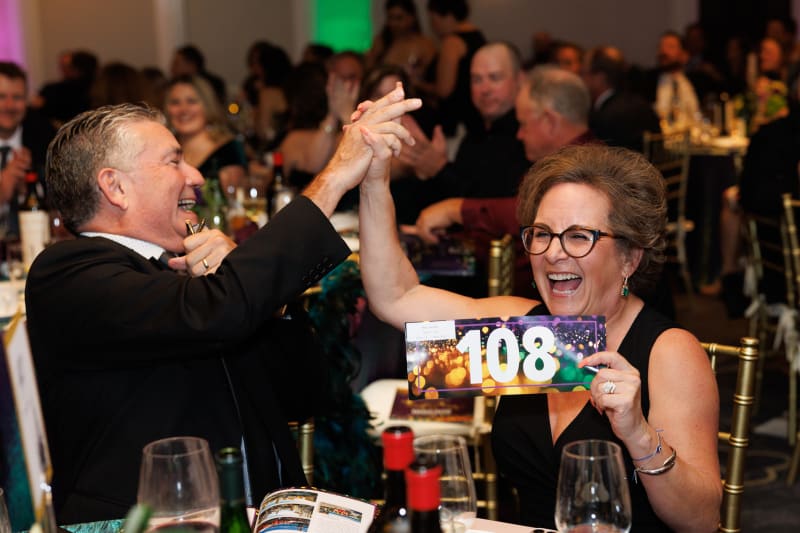 Guests celebrating a winning bid at the 2025 Advocacy Auction