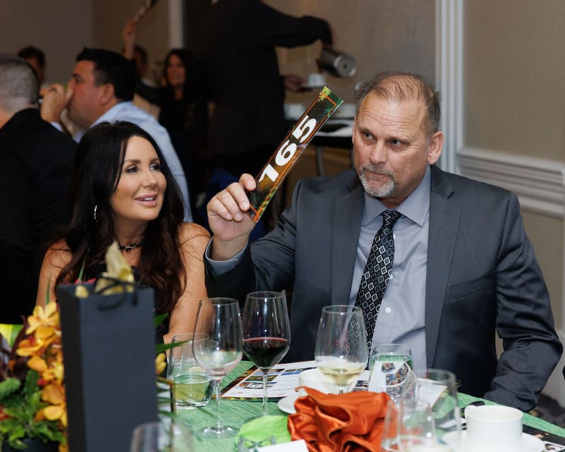 A guest raising his bid paddle at the 2024 Annual Auction