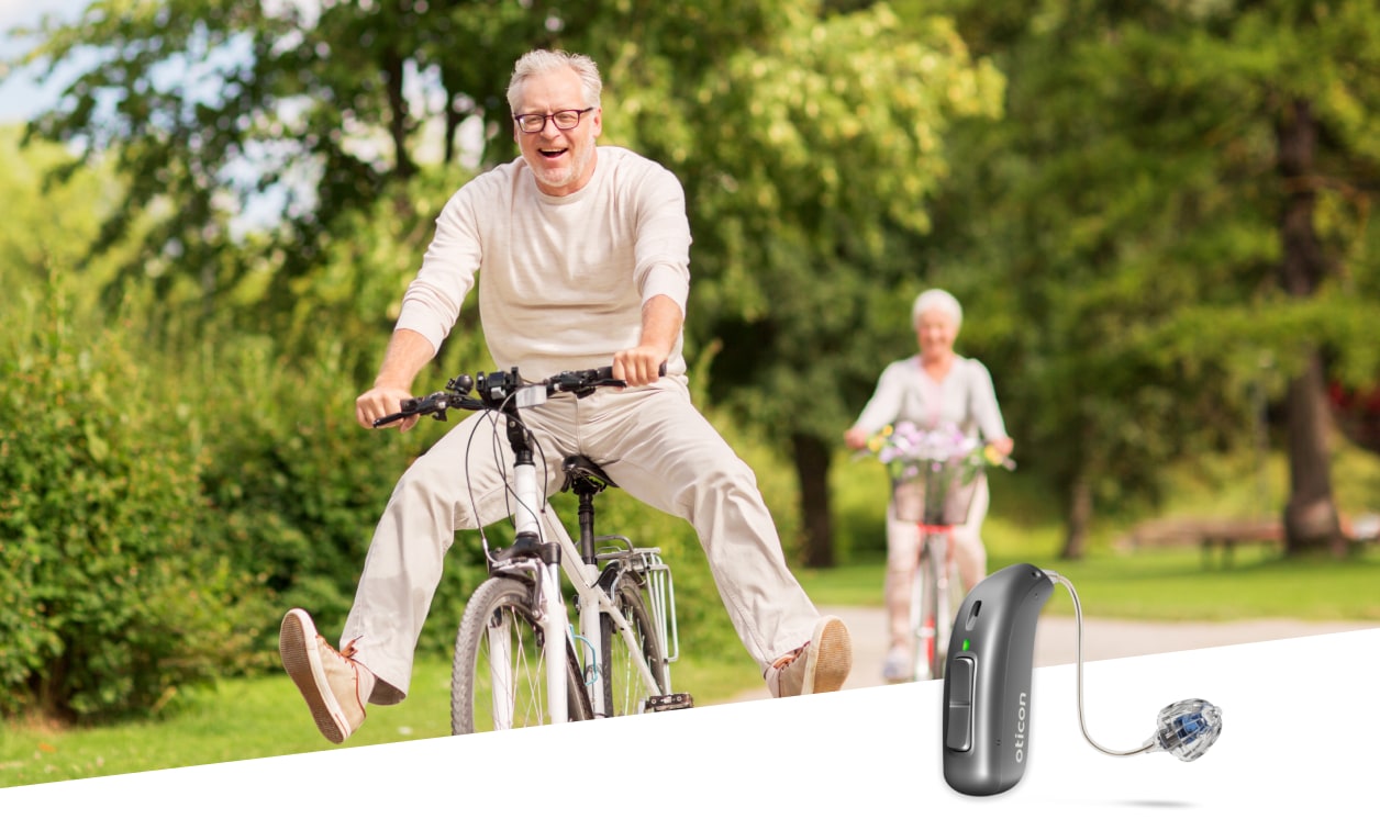 Person riding bike with Oticon hearing aid