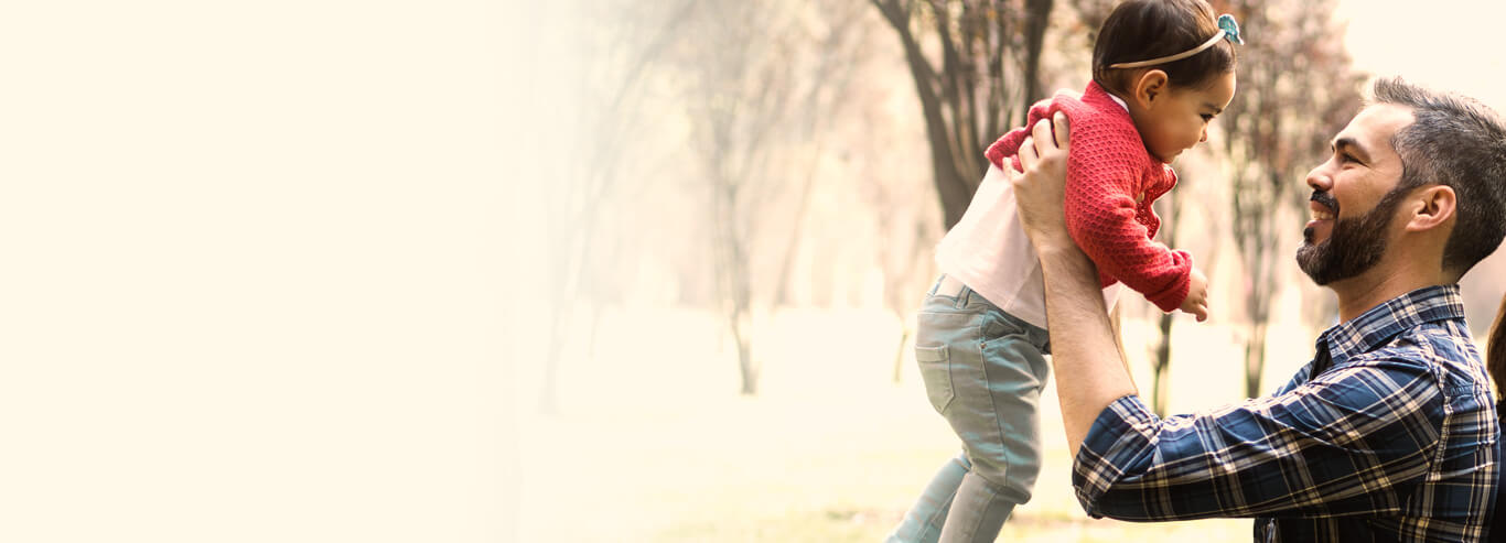 Dad holding daughter up in his arms