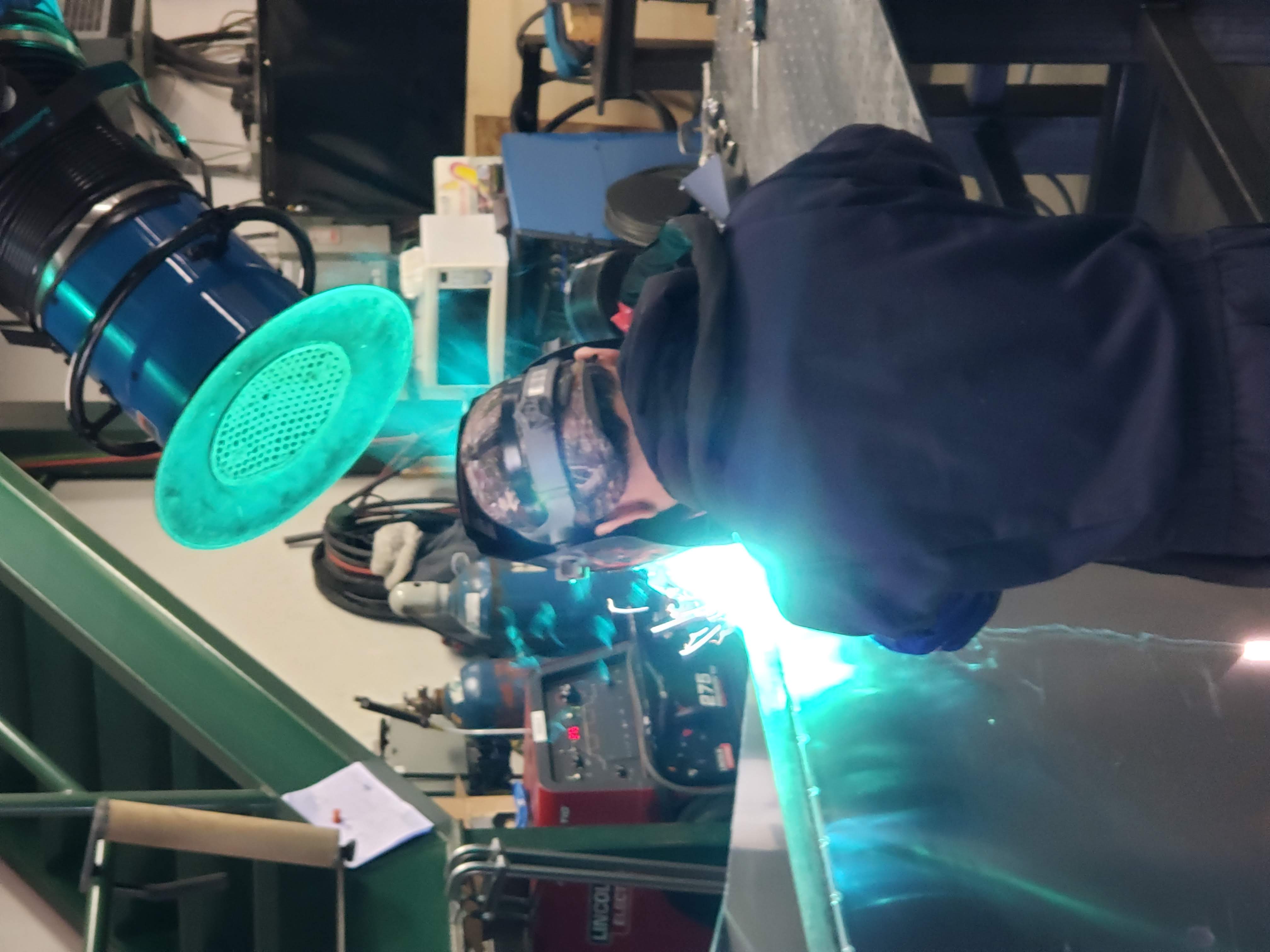 Close-up of a TIG welding process on a stainless steel assembly inside FortiFab's shop.