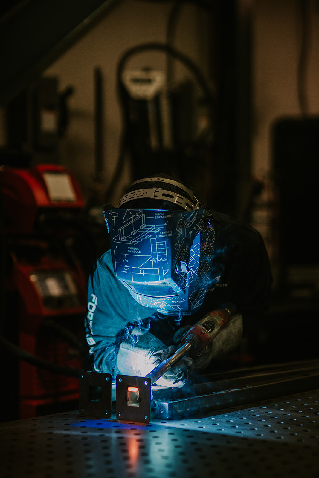 Welder producing a blue arc while joining stainless steel components.