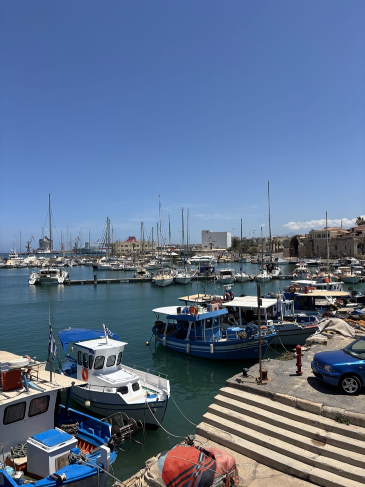 Charming Greek port with colorful fishing boats and traditional buildings lining the harbor