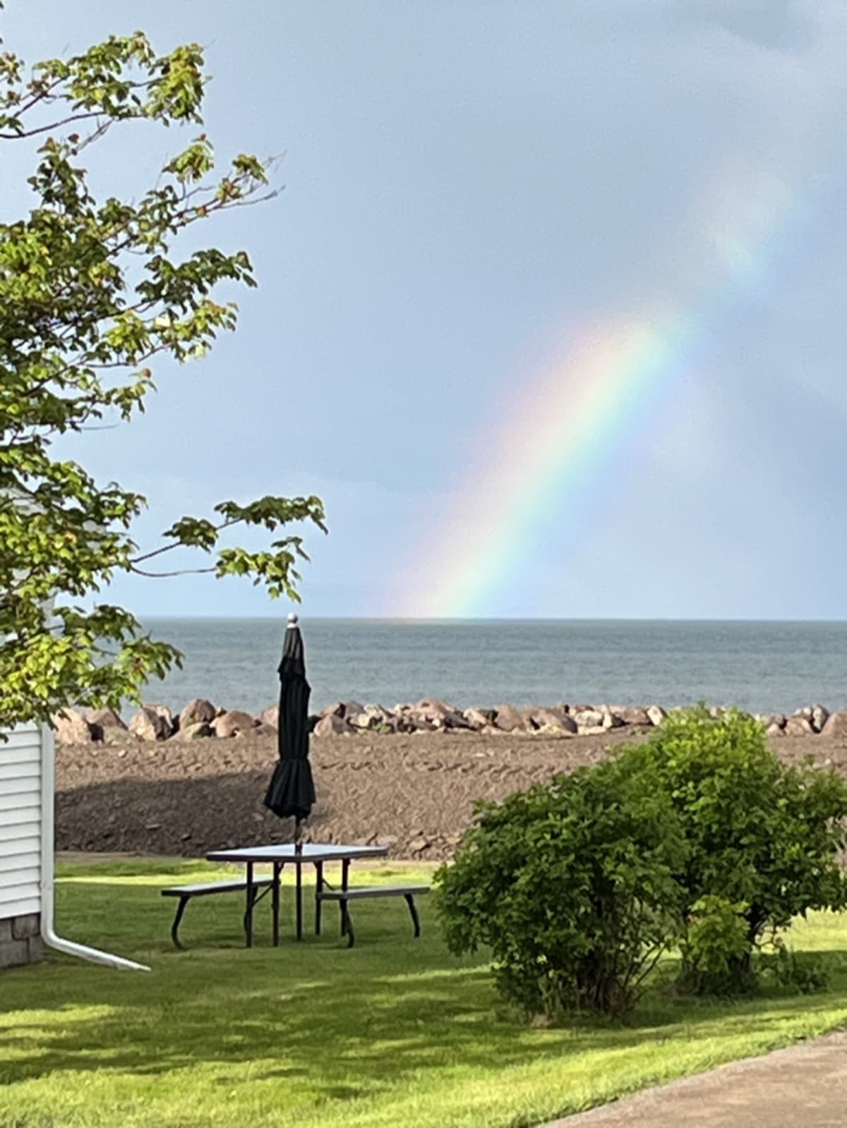 Embracing rainy days with proper gear - rain jacket, rain boots, and trail shoes to enjoy the beauty of rain and catch rainbows.