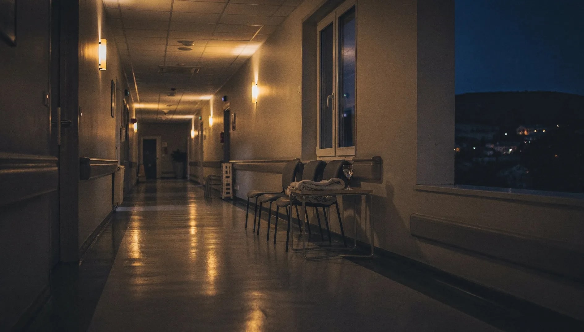 Couloir d'hôpital paisible au crépuscule évoquant la Mutuelle des Personnels du Centre Hospitalier d'Alès