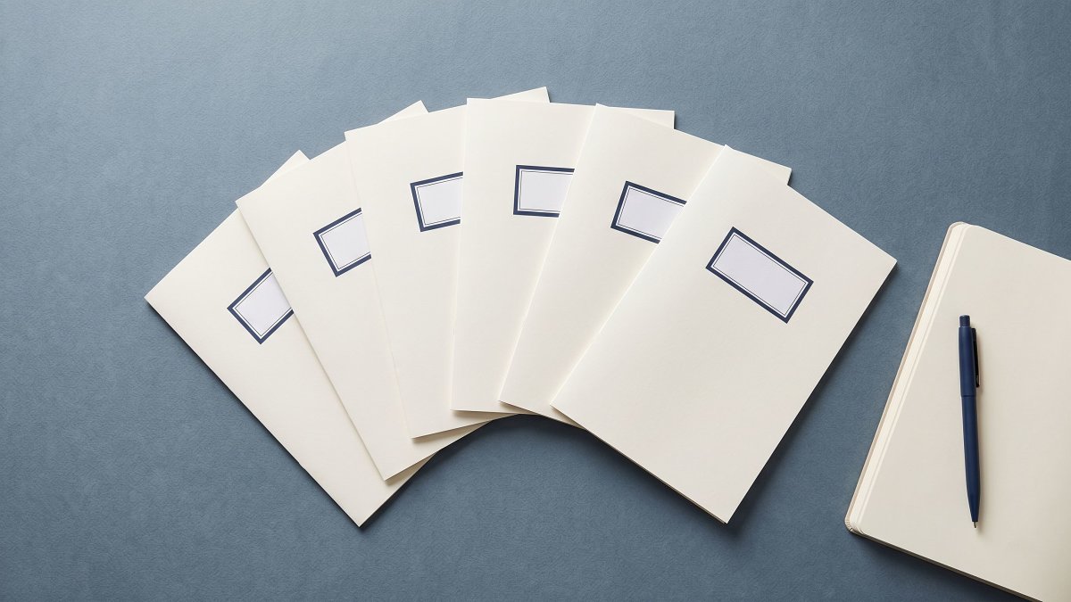 Seven labeled paper folders fanned across a studio workbench, one per engagement hub in the client engagement case study overview