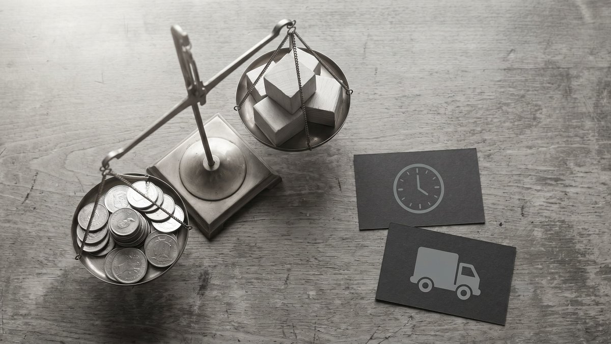 A balance scale weighing coins against building blocks, symbolising hourly cost against carried delivery risk