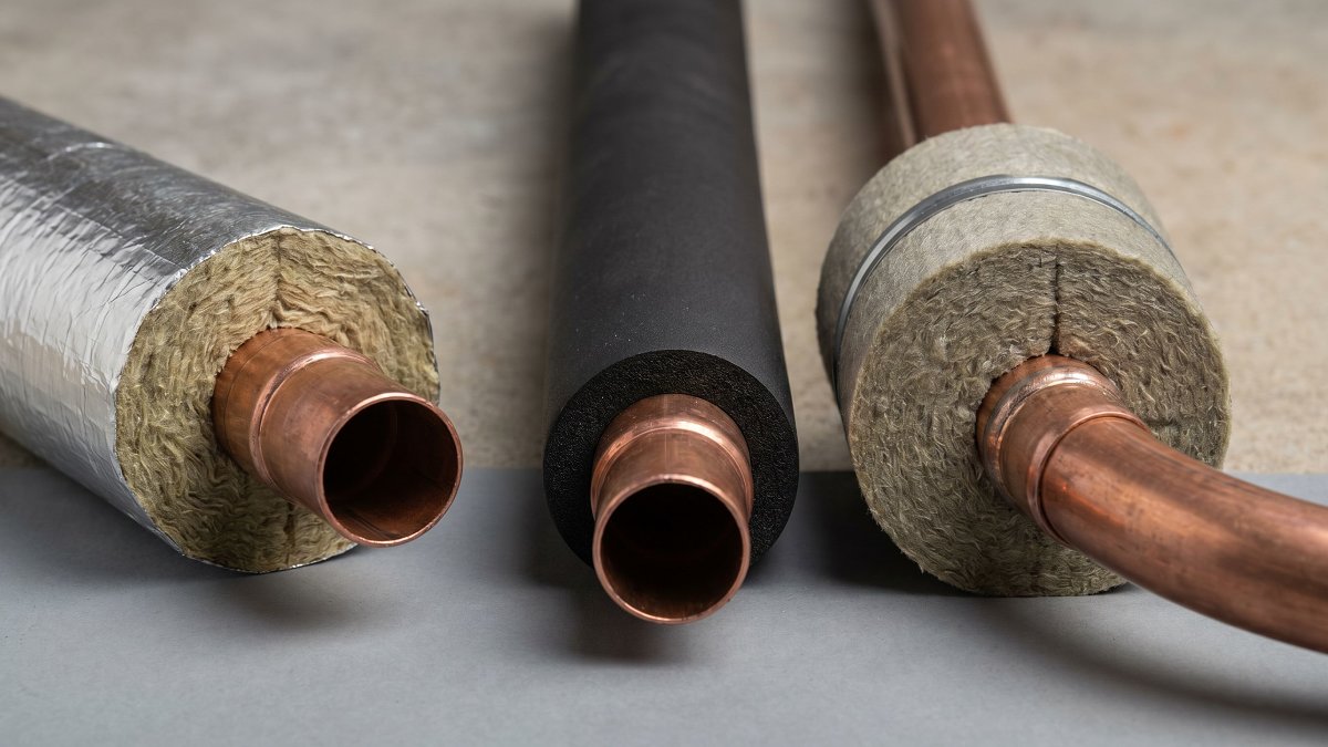 Trois isolants de calorifugeage posés sur des tuyaux de chauffage