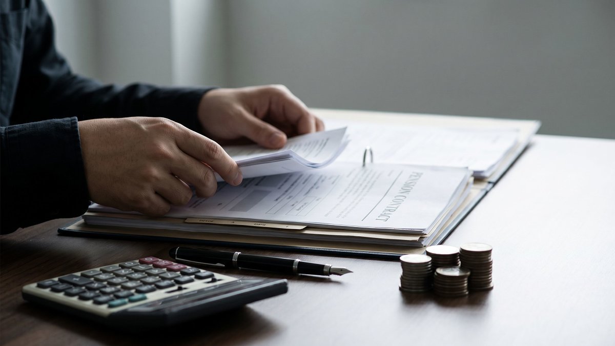Documents d'un contrat Madelin retraite et calculatrice sur un bureau