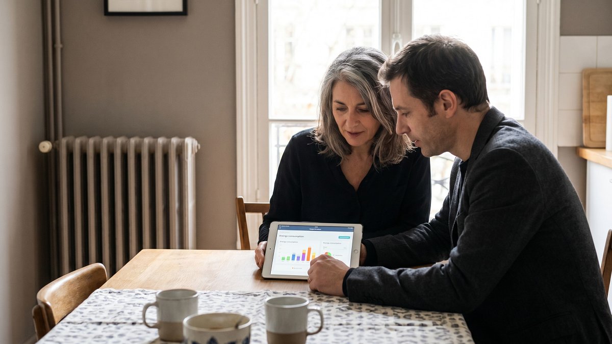 Propriétaire et conseiller comparant les options de chauffage sur une tablette