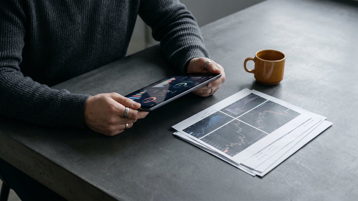 Mains analysant des données de marchés mondiaux sur une tablette, essor des ETF chez les particuliers en France