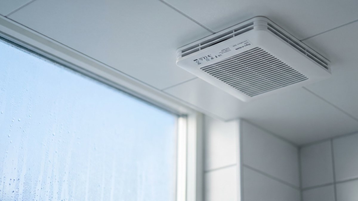 Bouche d'extraction hygroréglable au plafond d'une salle de bains, condensation sur la fenêtre