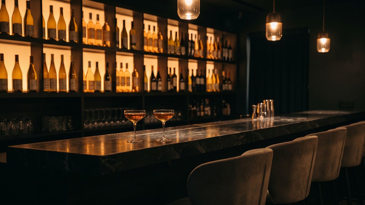 A kosher cocktail and wine bar counter in Tel Aviv at night with backlit bottles