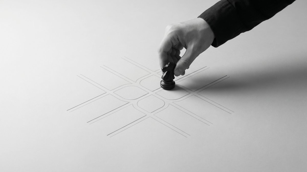 A hand placing a chess knight on a grid of branching paths, evoking choosing one engagement path