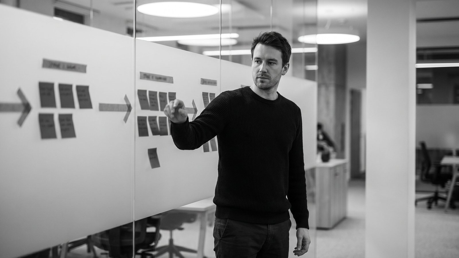 An operator reviewing an engineering hiring funnel on a studio wall board