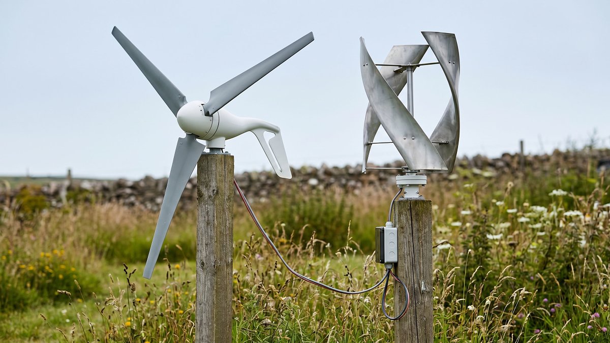 Éolienne domestique à axe horizontal et à axe vertical côte à côte dans un jardin rural