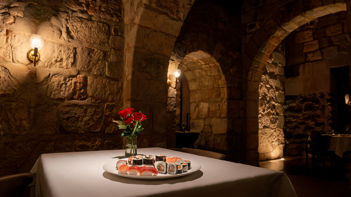 An intimate kosher restaurant in a restored 19th-century Jaffa stone building with sushi and low warm lighting