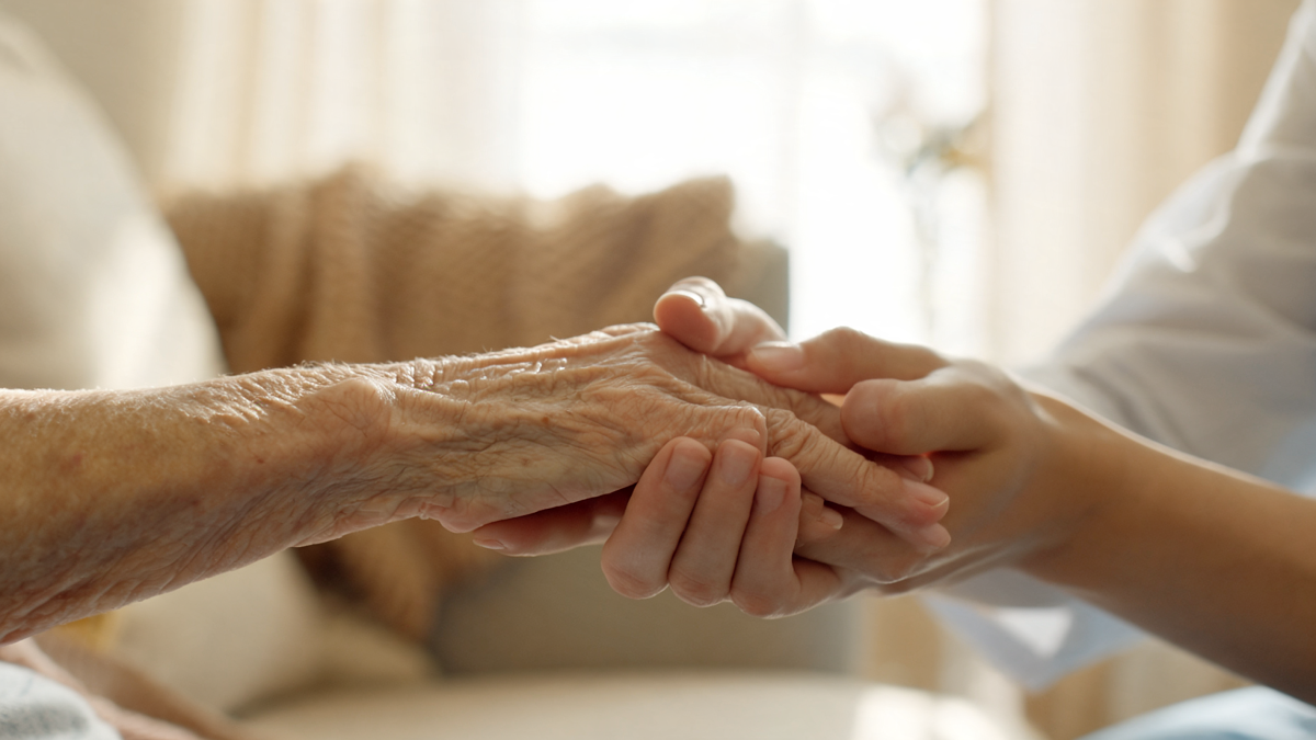 Aide à domicile assistant une personne âgée en perte d'autonomie couverte par une assurance dépendance