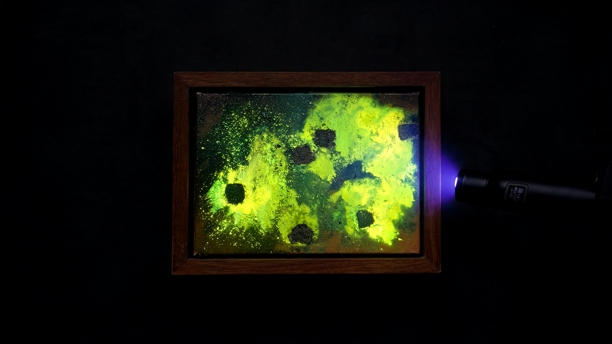 A framed painting under longwave ultraviolet light showing green-yellow varnish fluorescence and darker retouched areas