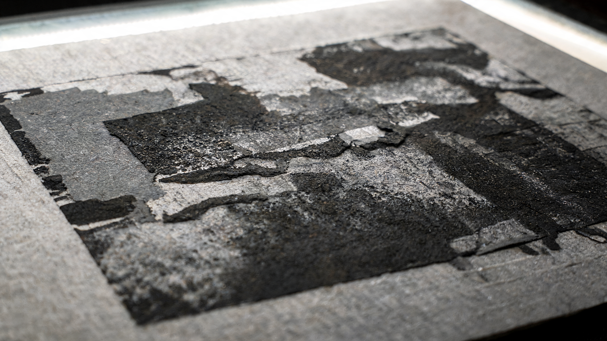 Close-up of a screenprint sheet margin and ink surface under raking inspection light